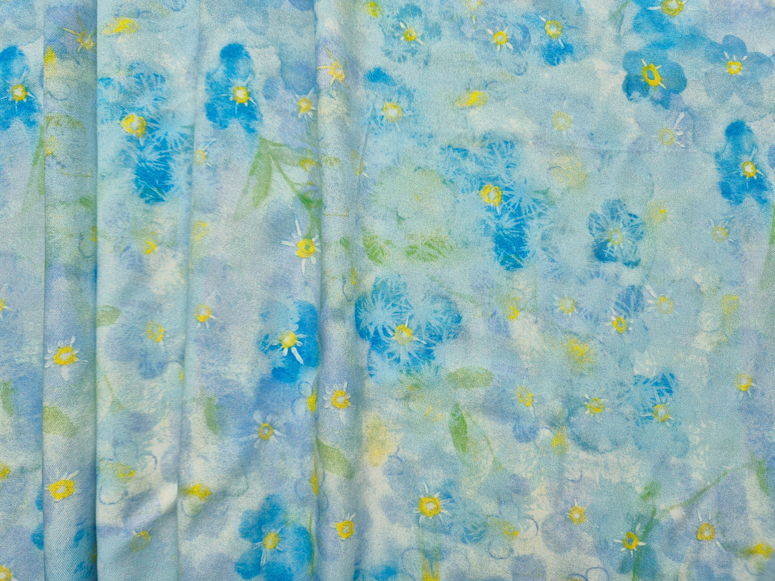 Õhuline ja elegantne viskooskangas, millel helesinistes toonides õied.